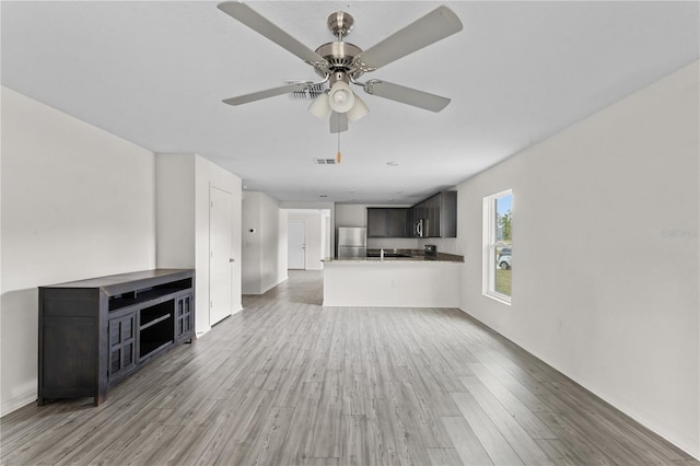 unfurnished living room with hardwood / wood-style flooring and ceiling fan