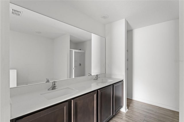 bathroom with vanity, wood-type flooring, and a shower with shower door