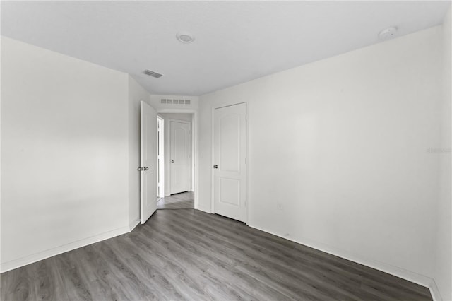 unfurnished room with dark wood-type flooring