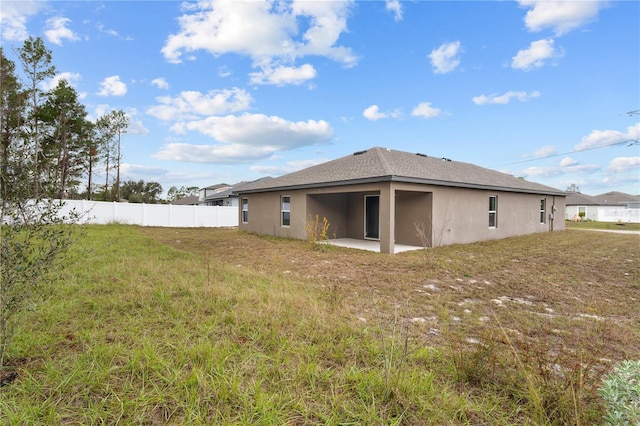 rear view of house featuring a yard and a patio