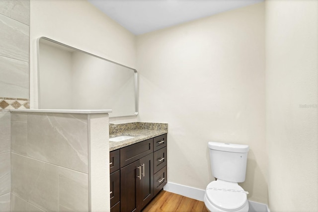 bathroom featuring wood-type flooring, vanity, and toilet