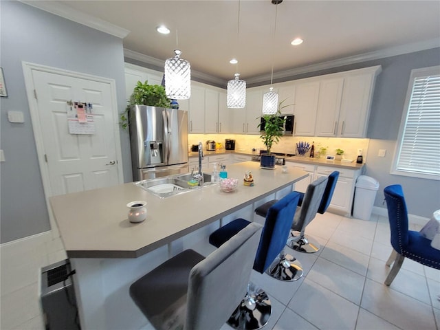 kitchen featuring sink, white cabinetry, stainless steel fridge, and a kitchen island with sink