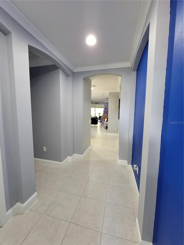 hall featuring light tile patterned flooring and crown molding