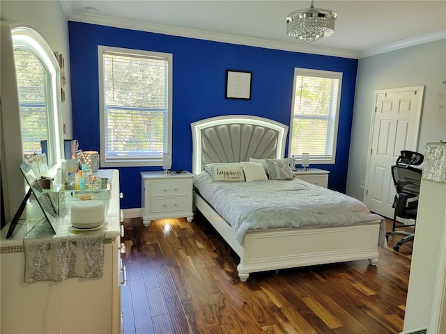 bedroom featuring dark wood-type flooring, ornamental molding, and an inviting chandelier