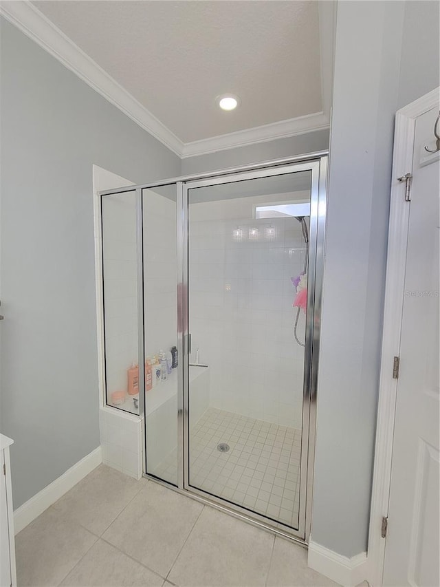 bathroom with a shower with shower door, tile patterned floors, and crown molding