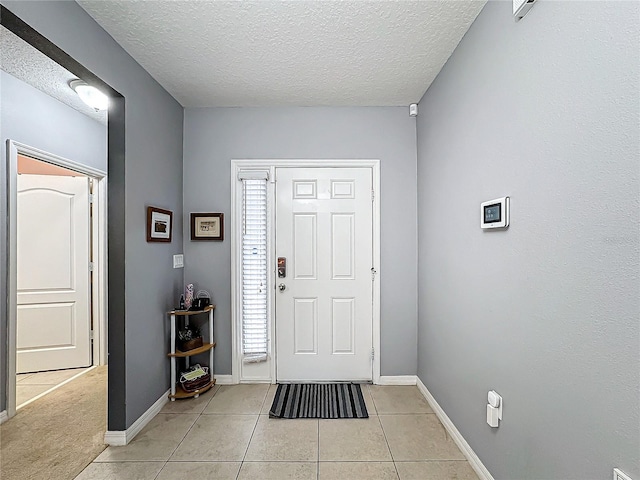 tiled foyer entrance with a textured ceiling and a healthy amount of sunlight