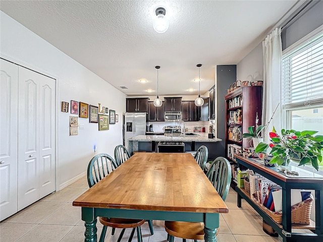 tiled dining area featuring a textured ceiling and sink