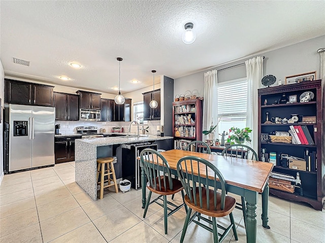 tiled dining area with a textured ceiling and sink