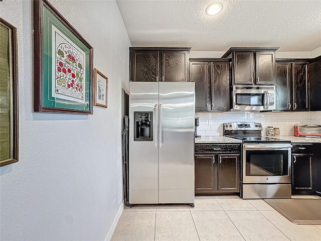 kitchen with decorative backsplash, appliances with stainless steel finishes, light tile patterned floors, and dark brown cabinets