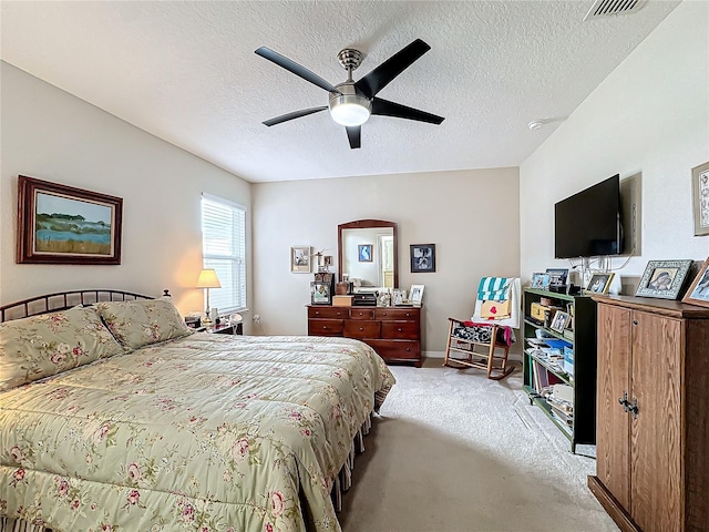 carpeted bedroom with ceiling fan and a textured ceiling