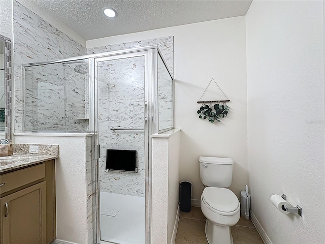 bathroom featuring a textured ceiling, vanity, a shower with door, tile patterned flooring, and toilet