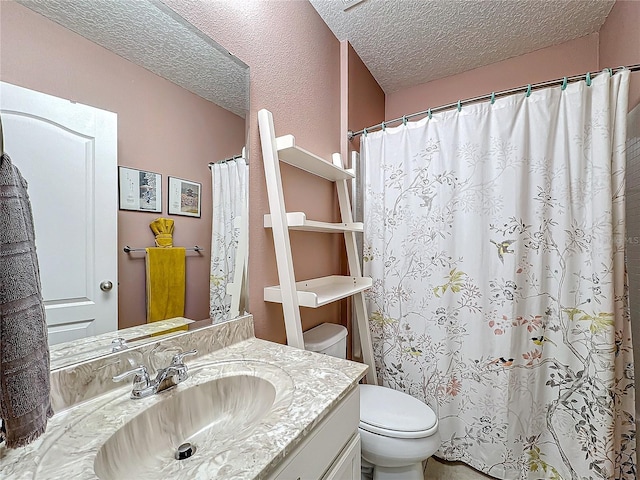 bathroom featuring vanity, toilet, and a textured ceiling