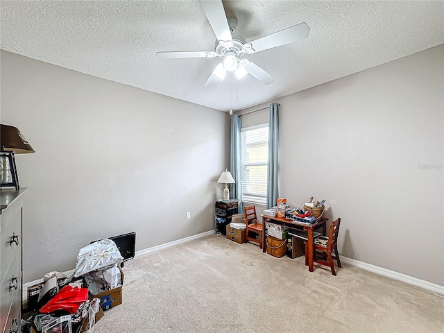 misc room with light carpet, ceiling fan, and a textured ceiling