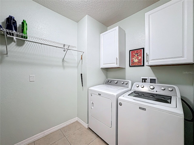 washroom featuring cabinets, light tile patterned floors, a textured ceiling, and independent washer and dryer