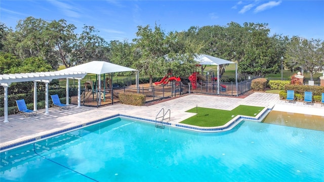 view of swimming pool with a pergola, a patio area, and a playground