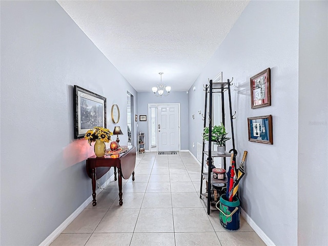 interior space with an inviting chandelier, a textured ceiling, and light tile patterned floors