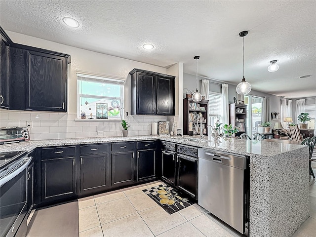 kitchen featuring sink, tasteful backsplash, hanging light fixtures, kitchen peninsula, and stainless steel appliances