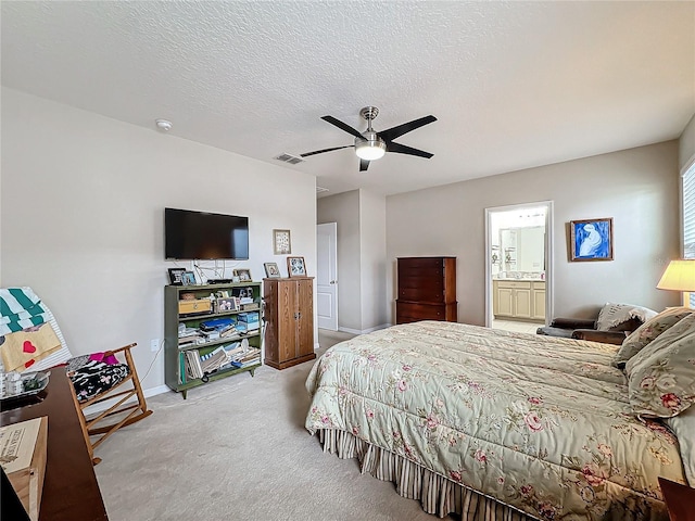 carpeted bedroom featuring ceiling fan, ensuite bathroom, and a textured ceiling