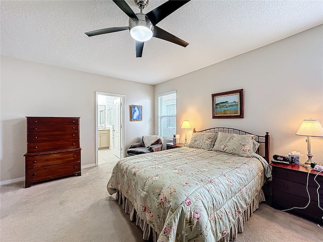 carpeted bedroom featuring ceiling fan, ensuite bathroom, and a textured ceiling