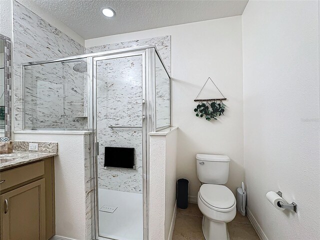 bathroom featuring a shower with shower door, tile patterned flooring, vanity, toilet, and a textured ceiling