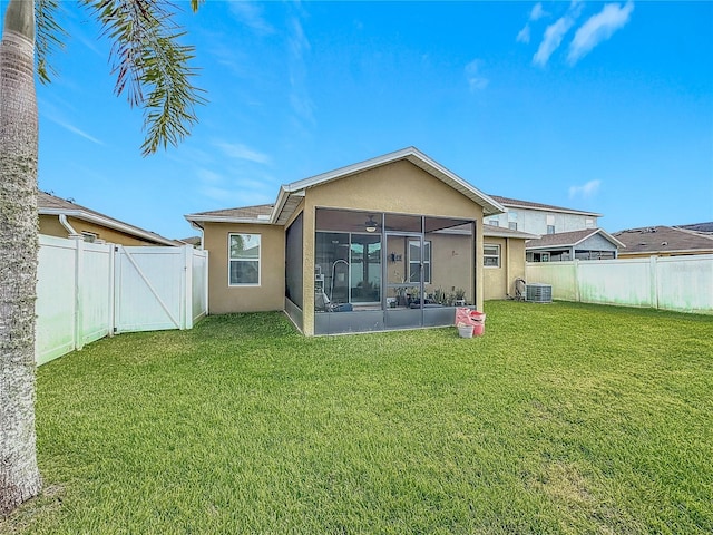 rear view of property with a yard, a sunroom, and central air condition unit