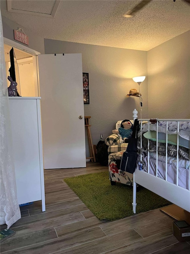 bedroom featuring a textured ceiling and dark wood-type flooring