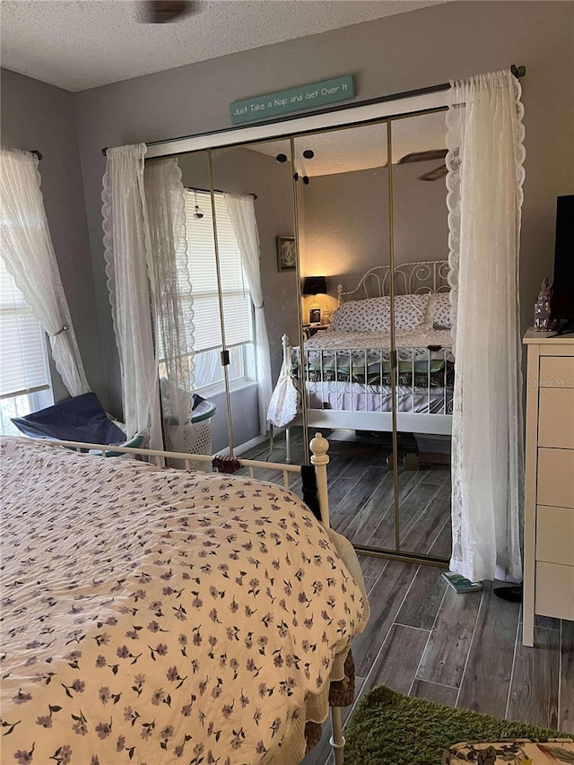 bedroom featuring a closet, dark wood-type flooring, and a textured ceiling