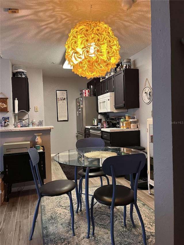 dining room with hardwood / wood-style flooring and a textured ceiling