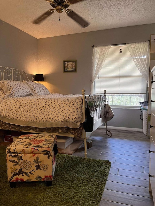 bedroom featuring ceiling fan, a textured ceiling, and hardwood / wood-style flooring