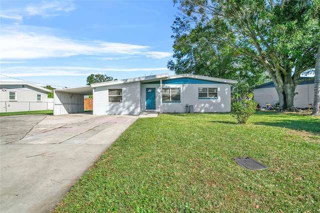 single story home featuring a front lawn and a carport