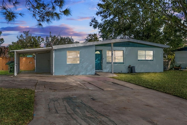 view of front of home featuring a carport and a yard