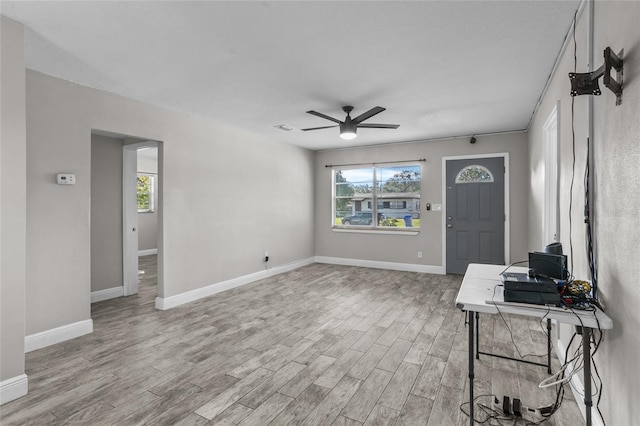 living room featuring a wealth of natural light, light hardwood / wood-style flooring, and ceiling fan