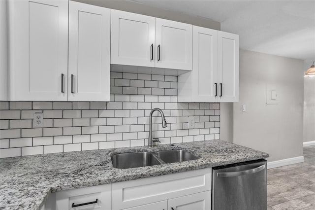 kitchen with white cabinetry, dishwasher, sink, tasteful backsplash, and light stone counters