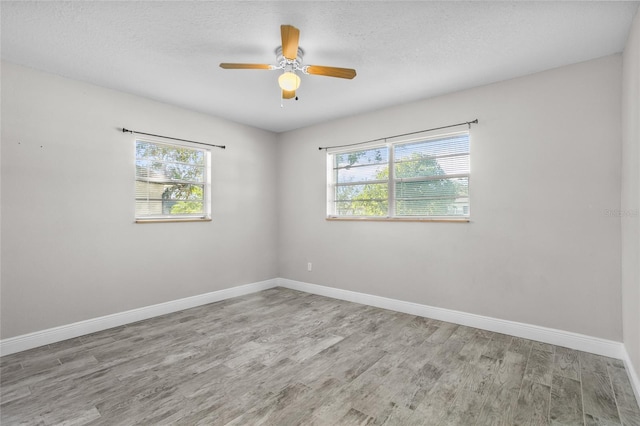 empty room with ceiling fan and light hardwood / wood-style floors