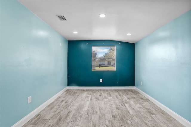 unfurnished room featuring light hardwood / wood-style flooring and vaulted ceiling