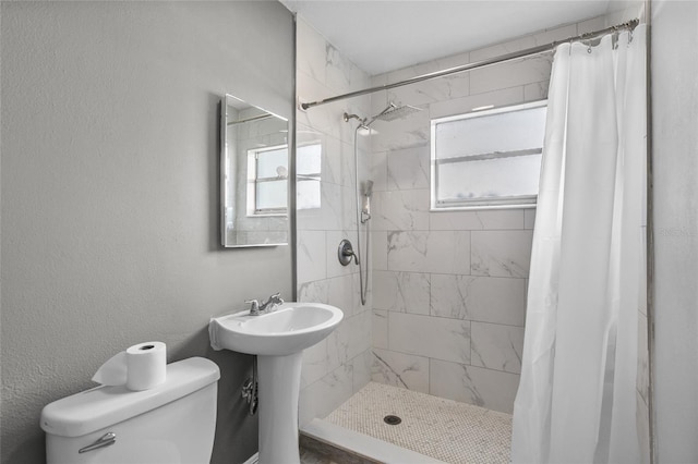 bathroom with toilet, plenty of natural light, and walk in shower