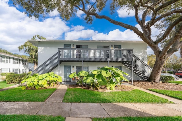 view of front facade featuring a deck and a front lawn