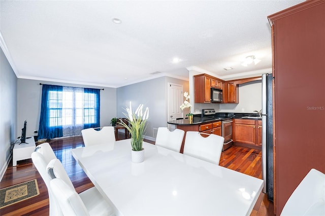 dining room with sink, dark hardwood / wood-style floors, and ornamental molding