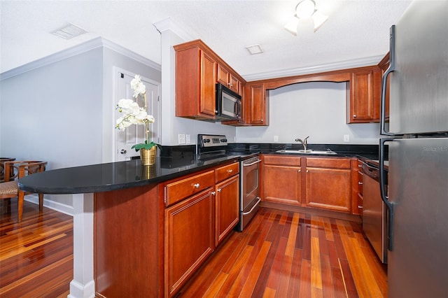 kitchen with sink, dark hardwood / wood-style floors, ornamental molding, a textured ceiling, and appliances with stainless steel finishes