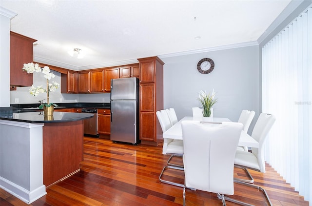 kitchen with a kitchen bar, stainless steel appliances, crown molding, dark wood-type flooring, and a center island