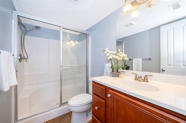 bathroom with vanity, toilet, and a shower with shower door