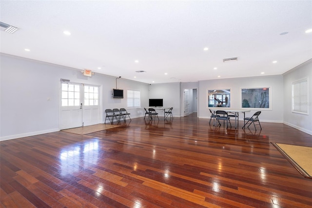 unfurnished living room featuring ornamental molding, french doors, and dark wood-type flooring