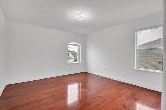 empty room with a textured ceiling and hardwood / wood-style flooring