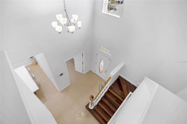 stairway with a towering ceiling and a notable chandelier