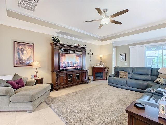 tiled living room with ceiling fan and ornamental molding