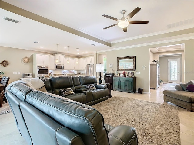 tiled living room with ceiling fan and crown molding