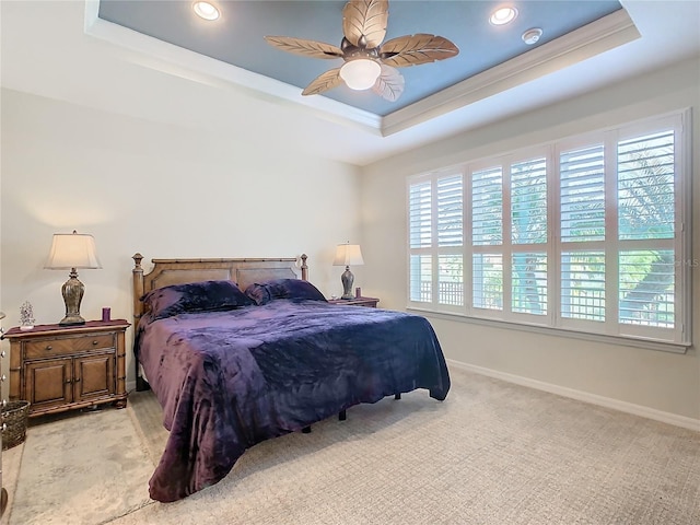 carpeted bedroom featuring a tray ceiling, ceiling fan, and ornamental molding