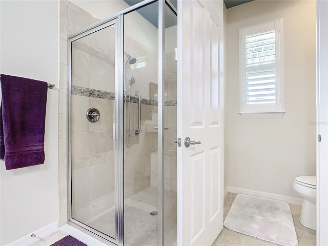 bathroom featuring tile patterned floors, toilet, and walk in shower