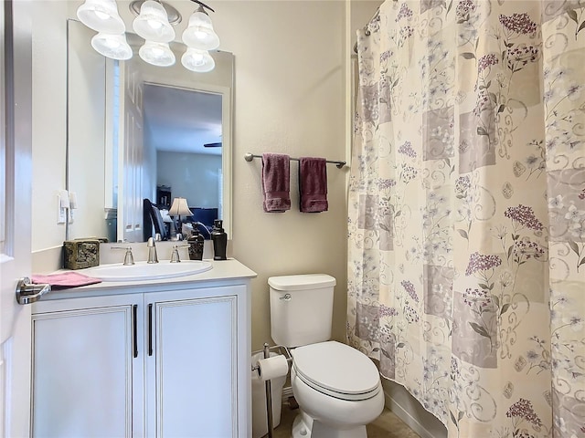 bathroom with curtained shower, vanity, and toilet