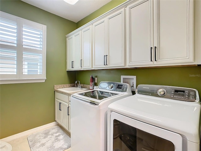 laundry area featuring cabinets, washing machine and dryer, light tile patterned flooring, and sink